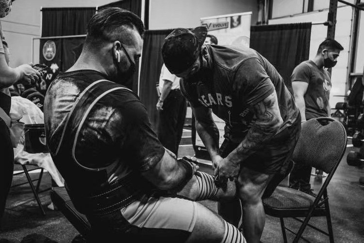 Paul (right) wrapping his athlete's knees at ShellShock powerlifting meet. (Edmonton, Alberta, Canada)