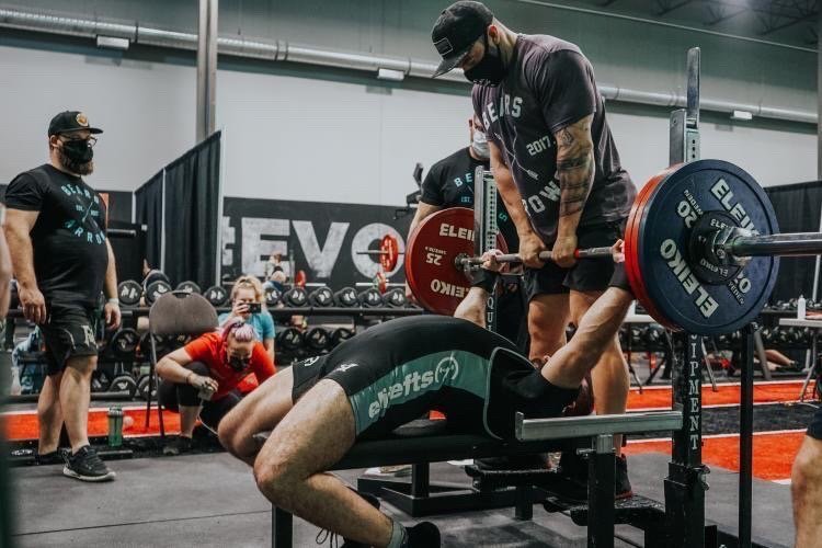 Paul (right) handing off benchpress for his athlete at ShellShock powerlifting meet. (Edmonton, Alberta, Canada)